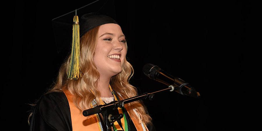 Laura Pierson speaking on stage at graduation